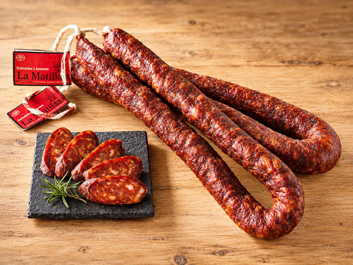 Chorizo artesano de La Matillana en sarta cortado en pizarra bajo madera 